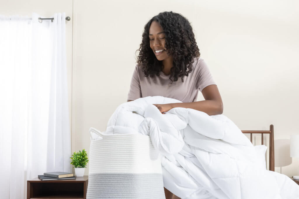 Woman putting her down alternative duvet in the wash basket