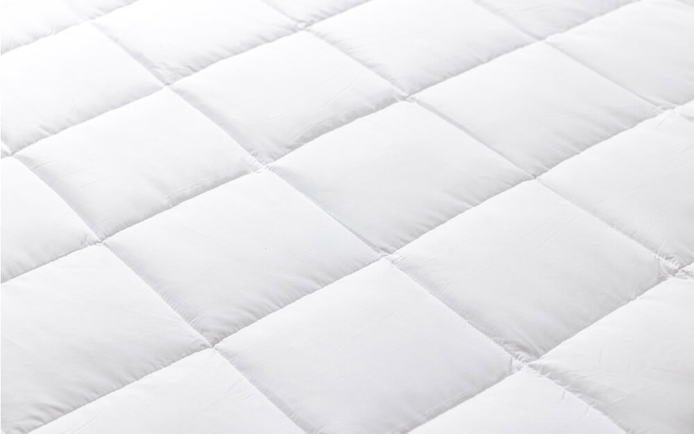 Vue rapprochée des panneaux matelassés de la couette en duvet synthétique