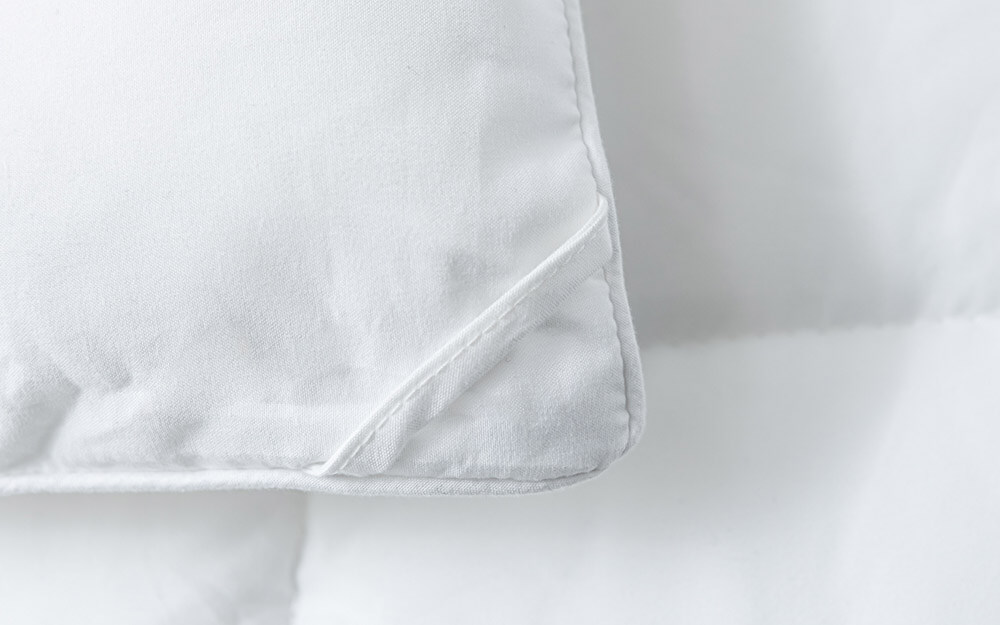 Une femme dort paisiblement sous sa couette en duvet synthétique