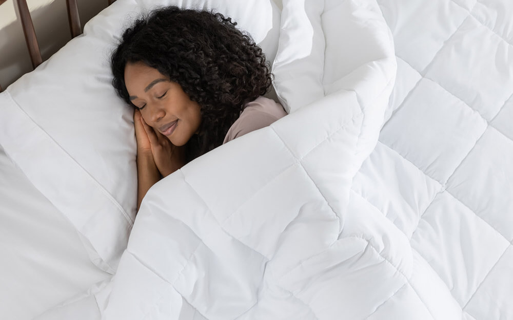 Woman sleeping peacefully, covered by her down alternative duvet