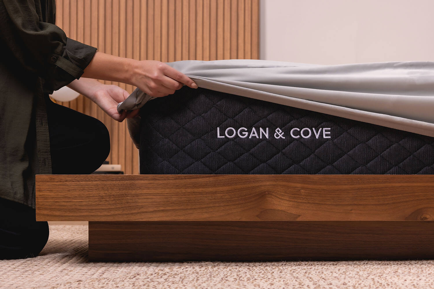 Woman pulling the fitted sheet of her Logan & Cove Bamboo Sheets over the corner on a mattress
