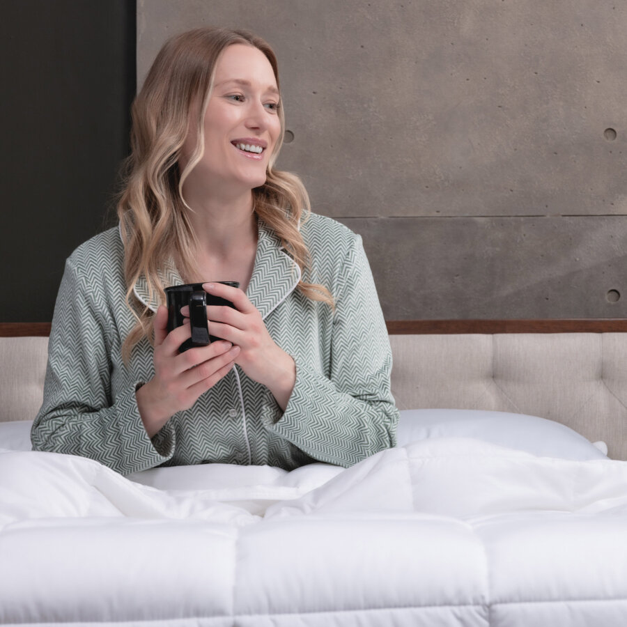 Woman smiling in bed with her Logan & Cove Down Alternative Duvet