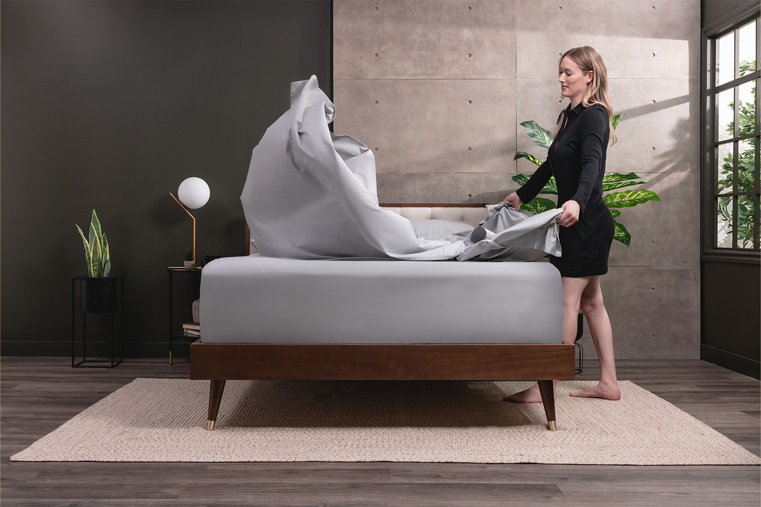 Woman waving the top sheet of a Egyptian Cotton Sheets on to a bed