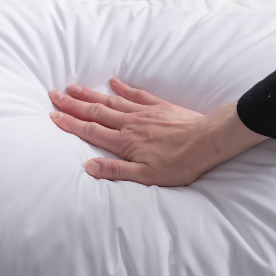 Hand pressing into the surface of a Logan & Cove Adjustable Memory Foam Pillow