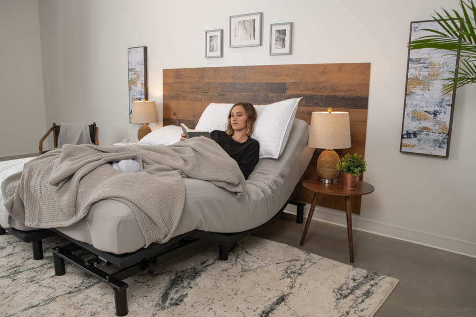 Woman reading in her Podium adjustable bed